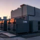 Hyperscale data center with large LFP battery storage units and copper cables at sunset.