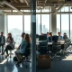 Contrasting scenes in a San Francisco tech office showing AI wealth winners celebrating and others facing layoffs