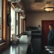 Small diner owner looking concerned with a help wanted sign in the window