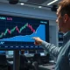 Financial analyst pointing to AUD/USD chart breaking above 0.72 on a trading floor screen