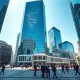 Canary Wharf financial district on a sunny day with workers walking through the plaza
