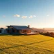 Aerial view of a luxury modern home in the Bay Area hills during sunset, symbolizing AI-driven real estate demand.
