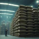 Stacks of burlap coffee bags in a dimly lit warehouse, representing shrinking inventories.