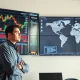 Coffee trader analyzing price charts and global supply data on multiple screens in a modern office