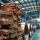Raw copper ore and refined copper coils in an industrial warehouse setting
