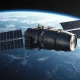 Orbital data center satellite in space with solar panels and integrated rocket stage, representing Cowboy Space's space-based AI compute concept.
