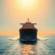 Large oil tanker navigating the Strait of Hormuz at sunset, representing global energy supply and geopolitical tensions.