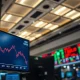 US dollar index chart showing decline on trading floor monitors amid geopolitical news