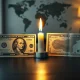 US dollar and Iranian rial banknotes with a peace candle on a desk, representing hopes for an end to the war.