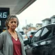 Concerned woman at gas pump with high fuel prices in a low-income neighborhood