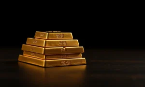 Stacked gold bars on a dark surface representing the precious metal's price stability above $4,700.
