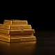 Stacked gold bars on a dark surface representing the precious metal's price stability above $4,700.