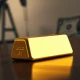 Gold bar with out-of-focus oil pumpjack and US dollar in background
