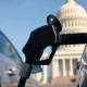 Fuel pump nozzle at a gas station with the U.S. Capitol building in the background