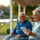 Retired couple reviewing finances on a porch overlooking a lake, representing retirement planning