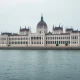 Hungarian Parliament building in Budapest on a cloudy day, representing economic policy and inflation analysis.