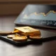 Gold bars and coins with a financial chart in the background representing sustained ETF inflows