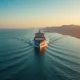 Aerial view of a large oil tanker navigating the Strait of Hormuz at sunrise, with the Iranian coastline in the background.
