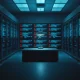 Empty desk in a high-security surveillance tech office with server racks and code on monitors in the background.