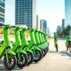 Row of Lime electric scooters and e-bikes parked on a city sidewalk