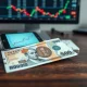 Malaysian ringgit banknote on a desk with a smartphone showing a forex chart.