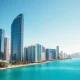 Miami skyline with modern towers and palm trees, New York skyline fading in background