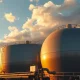 Natural gas storage tanks at a US Gulf Coast facility under partly cloudy afternoon sky
