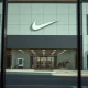 Exterior of a Nike store with legal document reflection, representing the class action lawsuit.
