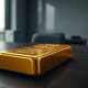 Gold bar with digital blockchain pattern projected on it representing a gold-backed stablecoin concept