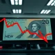 New Zealand Dollar banknote with descending red chart overlay on dark trading desk background