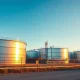 Oil storage tanks at sunrise, representing steady crude prices after market sell-off