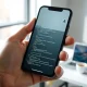 Person using OpenAI Codex on a smartphone in a modern office setting