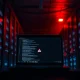 Dimly lit server room with laptop showing code and warning icon after OpenAI security breach