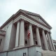 Exterior of the U.S. Department of Justice building in Washington, D.C., under overcast skies.