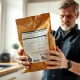 Concerned pet owner holding a bag of dry pet food in a kitchen, checking for recall information