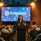 Pi Network co-founder Chengdiao Fan speaking at a Miami conference stage with blockchain graphics on screen