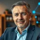 Nicolas Kokkalis, Pi Network co-founder, in a professional office setting with a digital network background