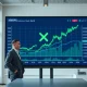 Financial analyst reviewing XRP price chart and Ripple revenue data on a digital display in a modern office.