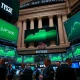 NYSE trading floor with green screens showing S&P 500 at record high during tech-led rally