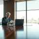 Two executives in a meeting room discussing pension risk transfer deal documents