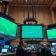 New York Stock Exchange trading floor with green screens showing record high S&P 500 index levels