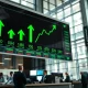Stock market display showing green gains on a trading floor during a rally
