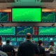 Stock exchange trading floor with green screens showing market gains