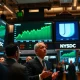 Stock exchange trading floor with green screens showing record high S&P 500 and Nasdaq indices