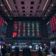 Stock exchange floor with screens showing mixed market data after inflation report