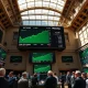 NYSE trading floor with green screens showing S&P 500 and Nasdaq at record highs during midday trading