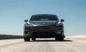 2026 Tesla Model Y driving on a highway under clear daylight