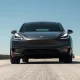 2026 Tesla Model Y driving on a highway under clear daylight