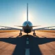 Boeing aircraft on tarmac at international airport with control tower in background