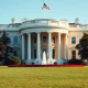 Exterior view of the White House under clear skies, representing US presidential authority and foreign policy decisions.